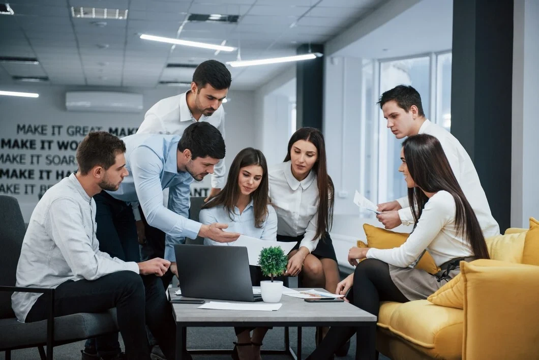 Business team reviewing documents around a laptop